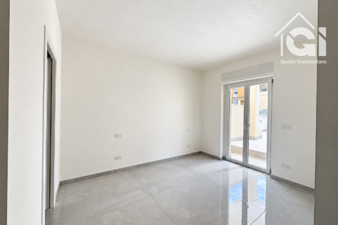 Camera vuota luminosa con accesso al terrazzo